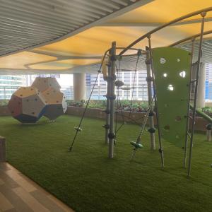 a play area with swings and a rock wall at Air Residences 4439 in Manila