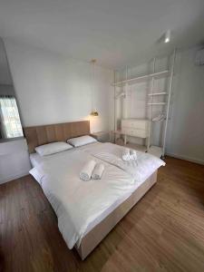 1 dormitorio con 1 cama blanca grande y 2 toallas en Time&Joy apartment with private pool en Kaštela