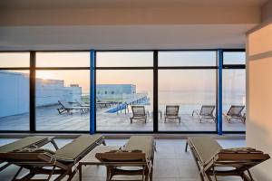 ママイアにあるCloud 9 Studio in Infinity Beach Resortのテーブルと椅子、大きな窓が備わる客室です。