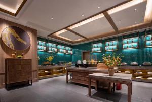 a restaurant with green walls and a table and benches at Morning Hotel, Loudi Changqing Street Louxing Square in Loudi