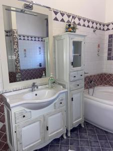 a bathroom with a sink and a tub and a mirror at VILLA HELENA in Lampedusa