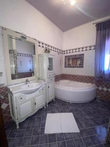 a bathroom with a tub and a sink and a bath tub at VILLA HELENA in Lampedusa