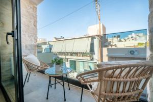 a balcony with chairs and a table and a view at FLOR28 STONE HOUSE in Heraklio