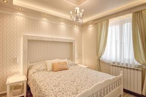 a bedroom with a bed and a chandelier at Apartments Zanetti in Pula