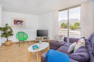 sala de estar con sofá púrpura y TV en MOLINS 1, en Cala de Sant Vicent