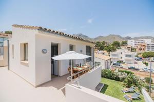 Casa blanca con balcón con sombrilla en MOLINS 1, en Cala de Sant Vicent