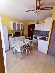cocina con mesa y cocina con electrodomésticos blancos en Joli studio cabine dans résidence en bord d'étang, en Le Barcarès