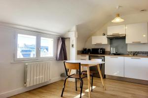 a kitchen with a table and chairs in a room at Studio Neuf Bien Agencé avec Ascenseur Port à 50M in Vannes