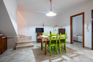 Un comedor con una mesa y sillas verdes. en Flower House in Villa carisciola, en Carovigno