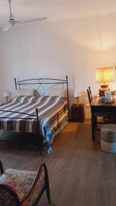 1 dormitorio con 1 cama y 1 mesa con lámpara en Affittacamere La Crognoleta, en Fonteblanda