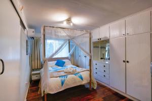 a bedroom with a bed and a dresser and a window at Yellow Cottage - bush and beach in Agnes Water