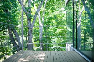 a screened in porch with trees in the background at COQ in Sapporo