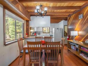 Lewis Ave Lodge في Tahoma: مطبخ مع طاولة طعام وكراسي خشبية