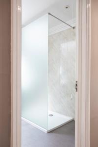 a shower with a glass door in a bathroom at Kingsley Lake View in Chew Stoke