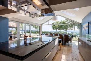 a kitchen with a glass counter and a dining room at Kingsley Lake View in Chew Stoke