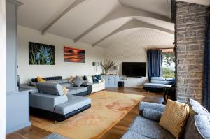 - un salon avec un canapé et une télévision dans l'établissement Kingsley Lake View, à Chew Stoke