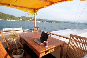 a wooden table on a boat with a laptop on it at Family labuan bajo in Labuan Bajo