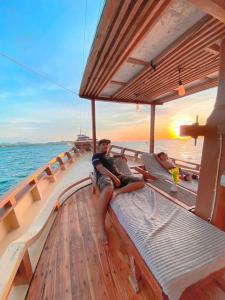 two people sitting on a boat in the ocean at Family labuan bajo in Labuan Bajo