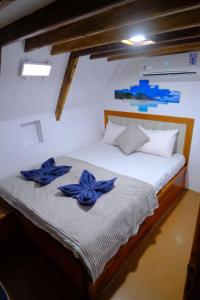 拉布安的住宿－Family labuan bajo，一间卧室,床上摆放着蓝色鲜花