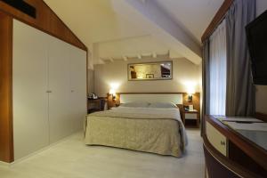 a bedroom with a large bed and a mirror at Albergo Celide in Lucca