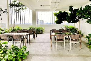 un restaurante con mesas, sillas y plantas en Super King-Sized Studio-Revo, en Kuala Lumpur