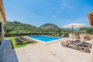 una piscina con tumbonas y sombrilla en Malagarba, en Pollensa