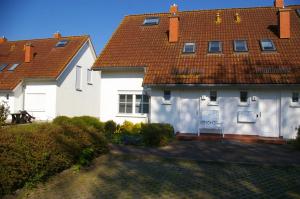 Casa blanca con techo rojo en Ferienwohnung Schwalbennest - a89292, en Garz