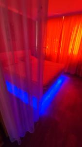 Cette chambre dispose d'un lit avec des lumières rouges et bleues. dans l'établissement Уютная люкс квартира в центре, à Uralsk