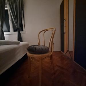 a chair with a pillow on it in a bedroom at Apartmani Katarina 4+2 in Biograd na Moru