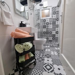 a bathroom with a black and white tile floor at Apartmani Katarina 4+2 in Biograd na Moru