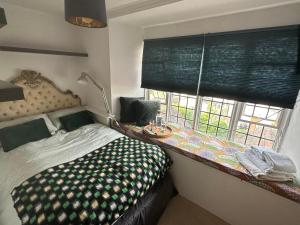 ein Schlafzimmer mit einem Bett neben einem Fenster in der Unterkunft Converted church in Beckenham
