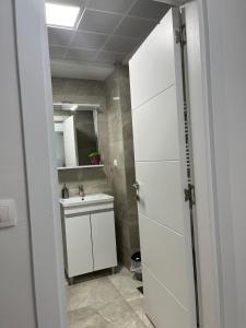 a bathroom with a sink and a white door at Skopje Centar Margarita Luxury Aprtment(Private Parking) in Skopje