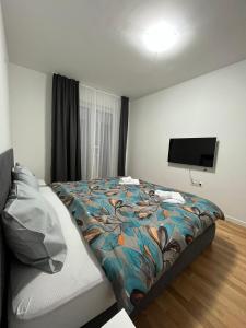 a bedroom with a bed and a flat screen tv at Skopje Centar Margarita Luxury Aprtment(Private Parking) in Skopje