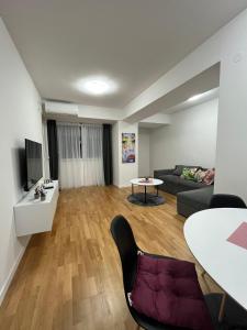 uma sala de estar com um sofá e uma mesa em Skopje Centar Margarita Luxury Aprtment(Private Parking) em Skopje