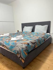 ein großes Bett mit farbenfroher Bettdecke darauf in der Unterkunft Skopje Centar Margarita Luxury Aprtment(Private Parking) in Skopje