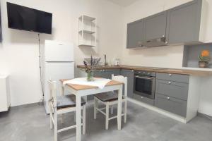 a kitchen with a white table and a white refrigerator at 44 gatti Grazioso monolocale in San Salvo