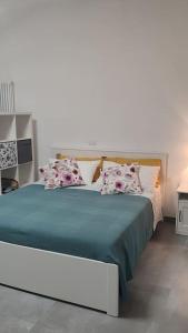 1 dormitorio con 1 cama con sábanas y almohadas azules en 44 gatti Grazioso monolocale en San Salvo