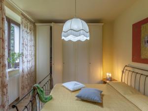 - une chambre avec un lit et un lustre dans l'établissement Inviting Holiday Home in San Costanzo with Swimming Pool, à San Costanzo