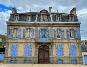 an old building with blue doors and windows at Maison d'Hercule in Mayenne