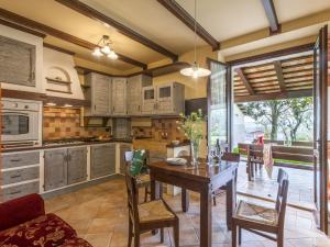 cocina con mesa de madera y sillas en Inviting Holiday Home in San Costanzo with Swimming Pool, en San Costanzo