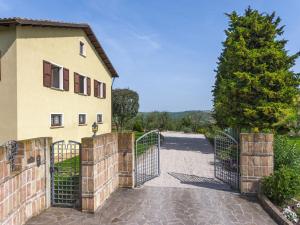 una entrada a una casa con una puerta y un árbol en Inviting Holiday Home in San Costanzo with Swimming Pool, en San Costanzo