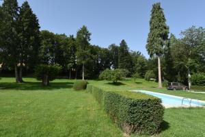 a hedge next to a swimming pool in a park at Chambres d'hôtes La Babinerie in Saint-Léonard-de-Noblat