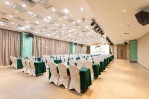 a large room with rows of chairs and a screen at Santavan Hotel Shenzhen Guangming in Bao'an
