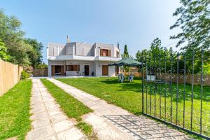 a house with a gate in front of a yard at Apartment corfu in Lefkímmi