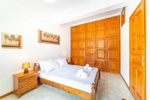 a bedroom with a bed and a wooden door at Apartment corfu in Lefkímmi