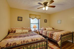 - une chambre avec 2 lits et un ventilateur de plafond dans l'établissement Cadiz Vacation Home with Deck Walk to Lake Barkley, à Cadiz