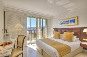 a bedroom with a bed and a desk and a window at Hôtel West End Promenade in Nice +37 photos