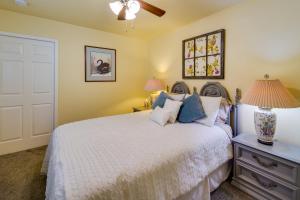 a bedroom with a white bed and a lamp at Sunny California Retreat with Pool Access and Patio! in Shasta Lake