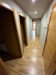 a hallway with two open doors and wooden floors at Carlos III Foz in Foz +5 photos