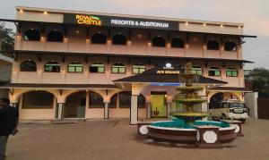 a large building with a fountain in front of it at ROYAL CASTLE HOTEL in Mananthavady